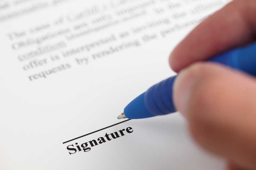 Businessman signing contract. Focus on the end of ballpoint pen. Shallow depth of field. Close-up.